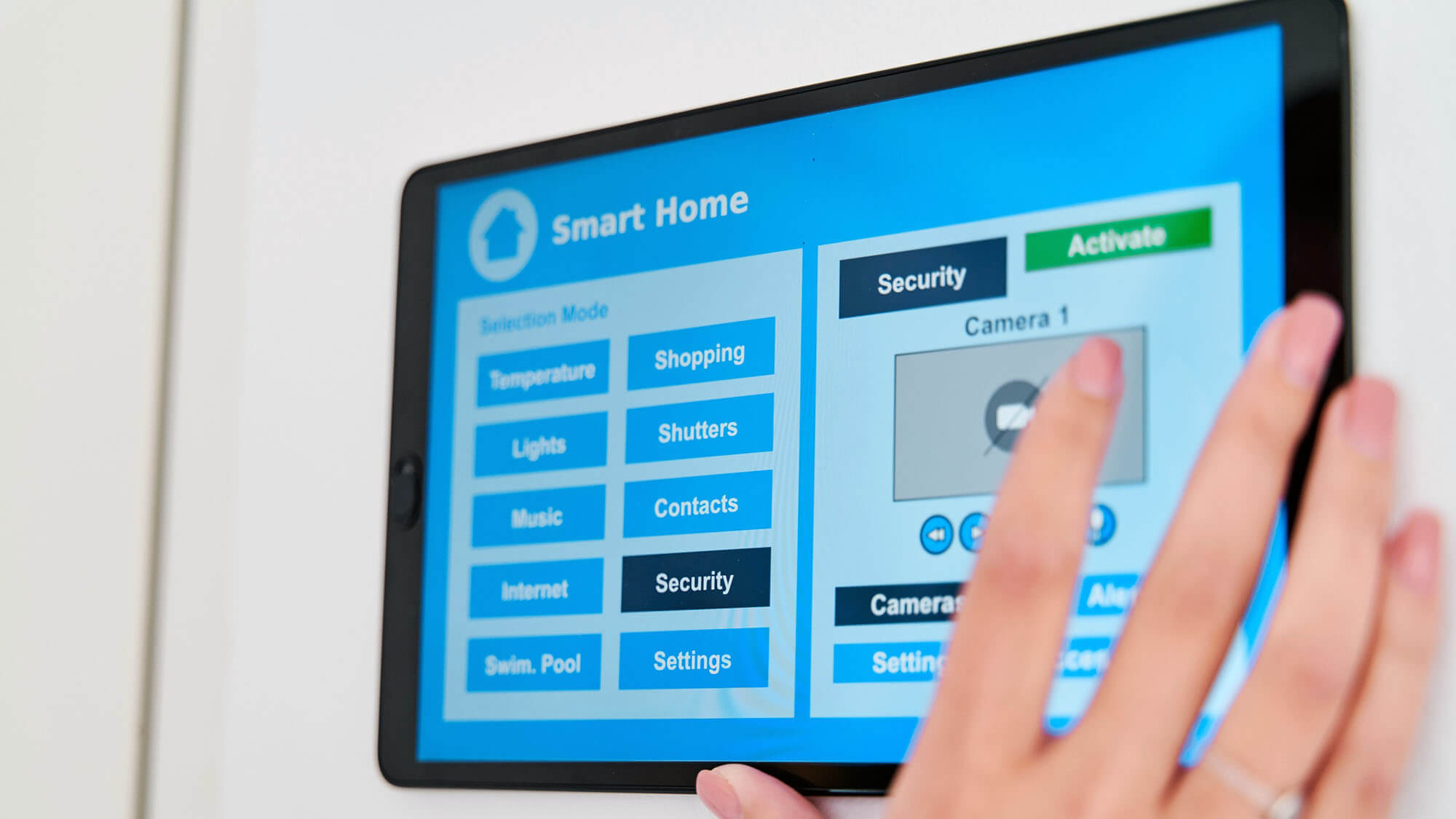 Woman using an application on her digital tablet to control the security and video vigilance of her smart home.