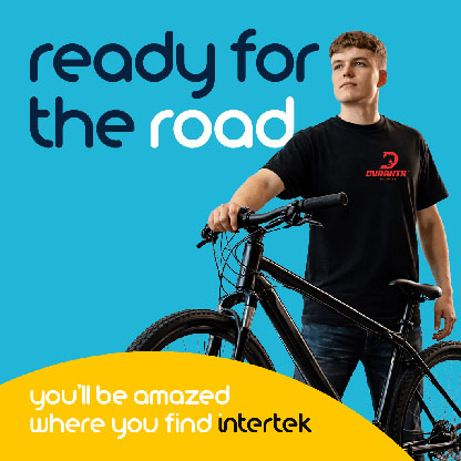 A young man with a Duranta t-shirt standing next to a mountain bike